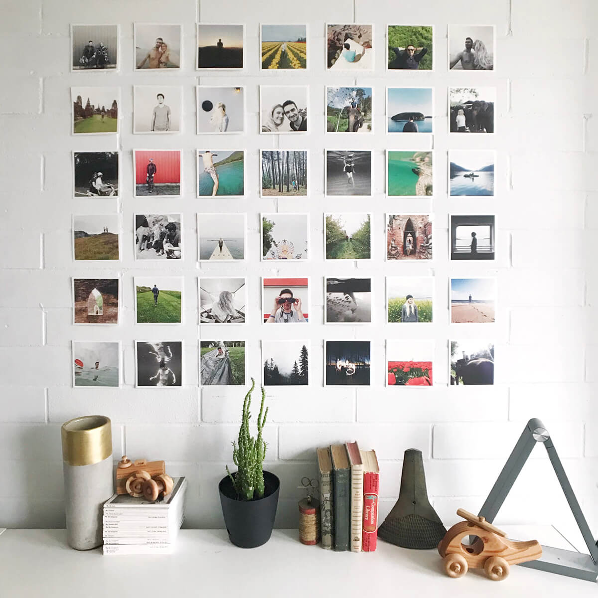 Square grid arrangement of photo prints on wall