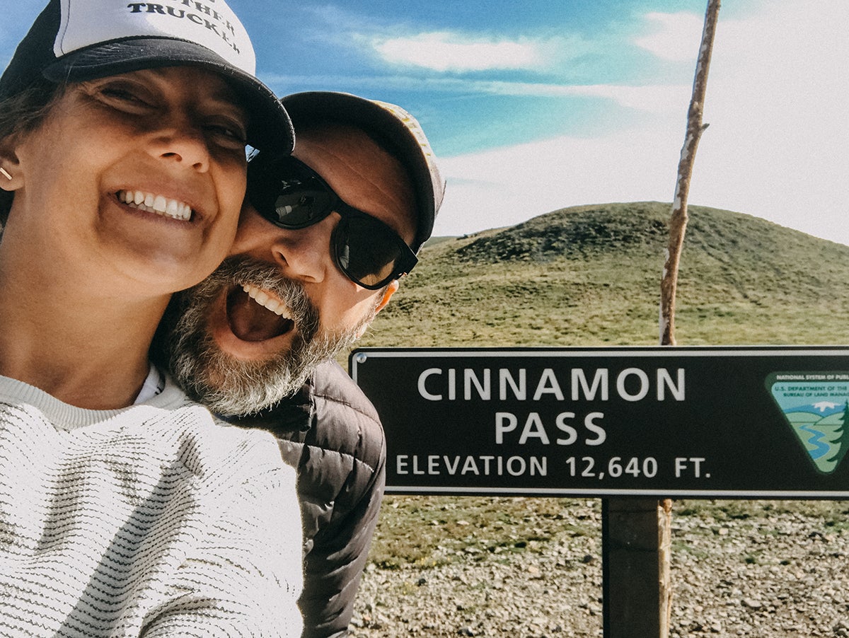 Liz young with husband by Cinnamon Pass sign