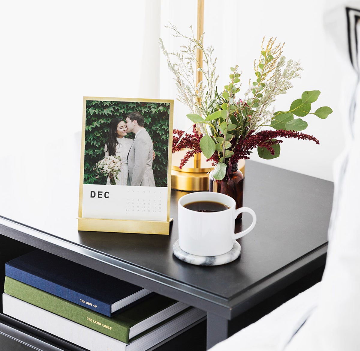 Brass easel photo holder with wedding print on bedroom side table