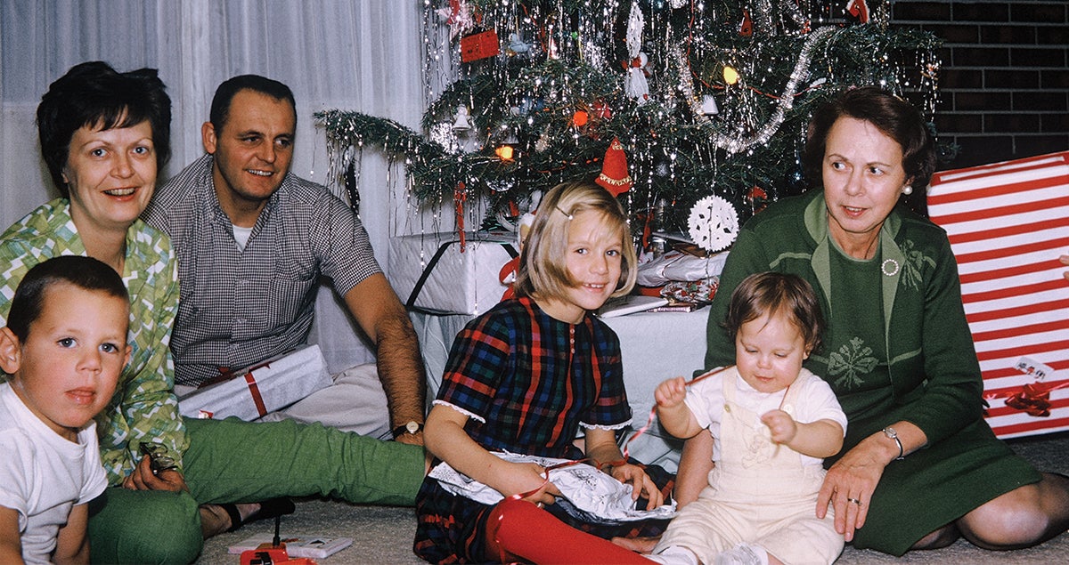 Vintage photo of family opening gifts by tree