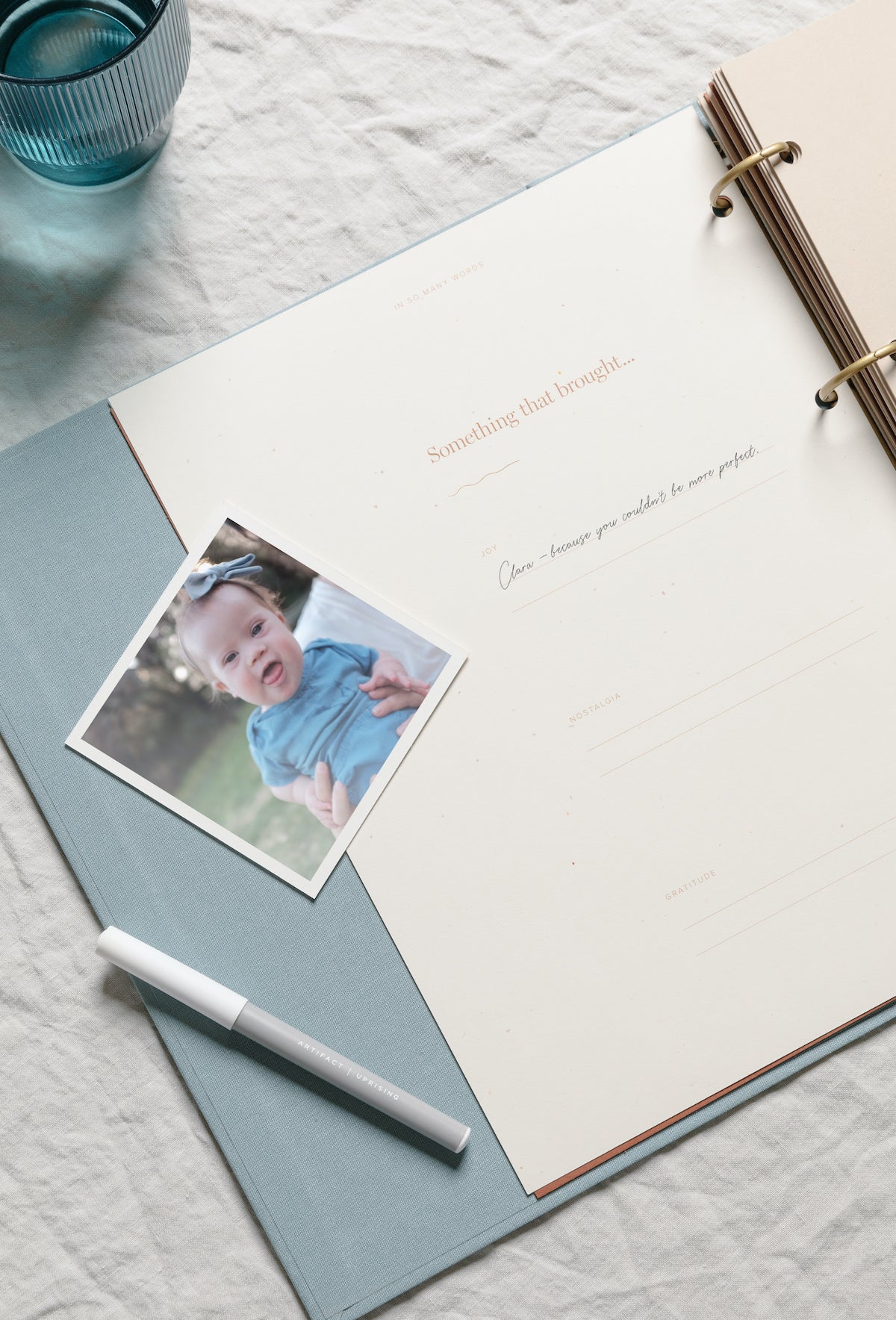 Photo of baby girl next to open scrapbook with writing inside