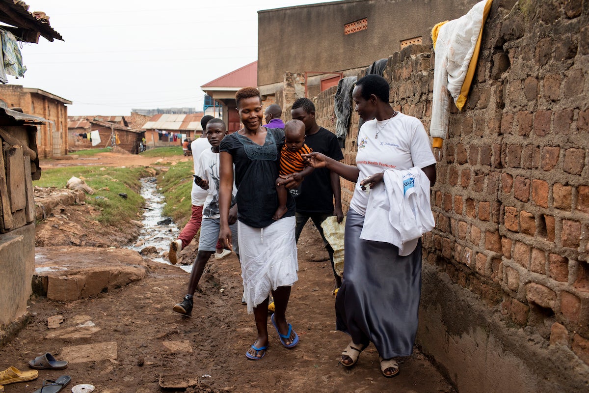 Locals walk down an unpaved alley