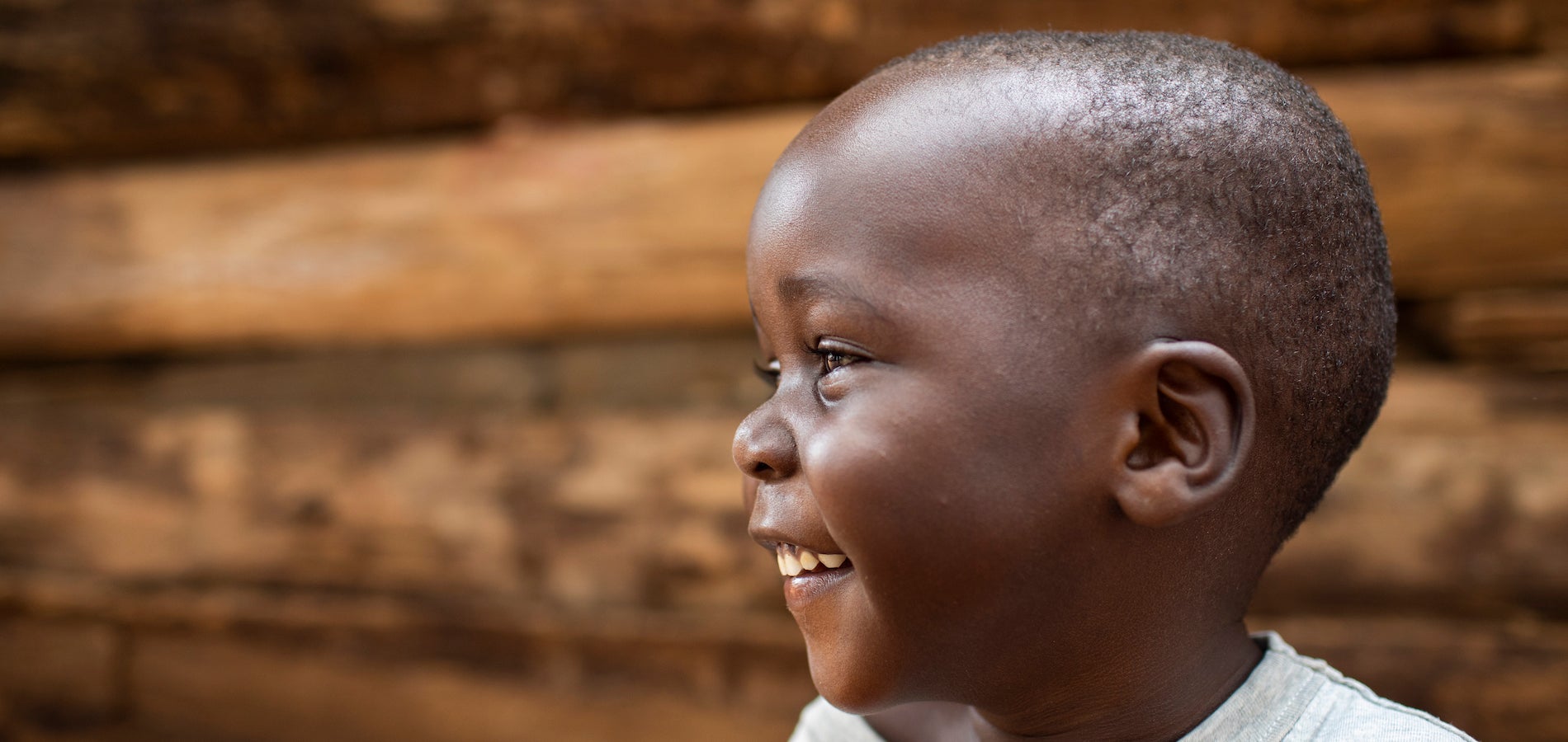 Close up of a little boy smiling with his head turned to the side