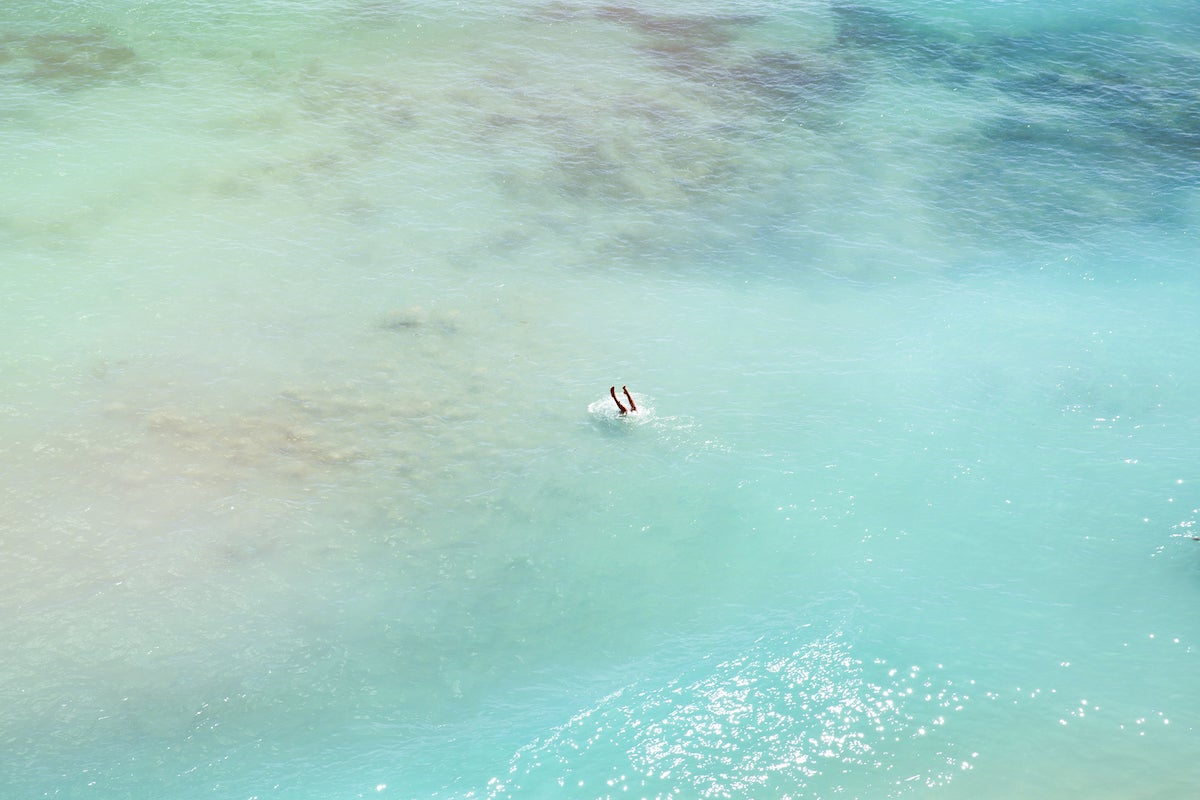 Overhead photo of someone doing a headstand in the ocean