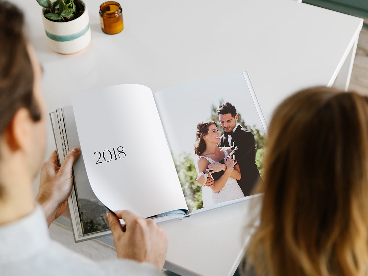 Hardcover Photo Book opened up to spread with 2018 on the left page and a wedding photo of a couple on the right page