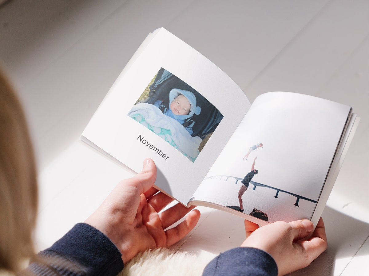Softcover Photo Book opened to page marked November featuring baby photo