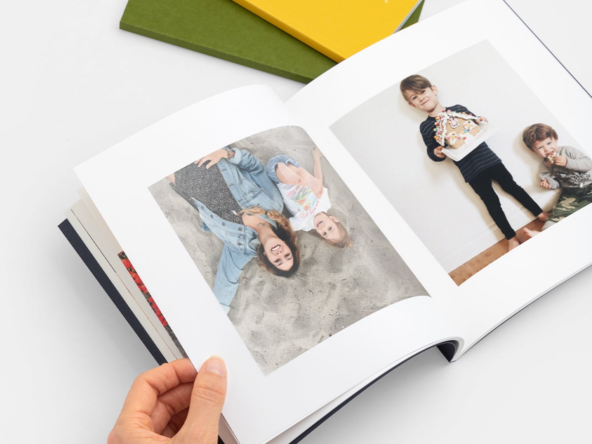 Photo book opened to images of children with gingerbread house