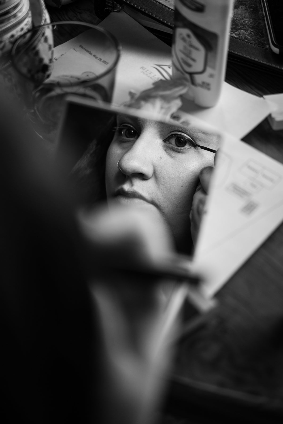 Bride's reflection in the mirror as she does her makeup