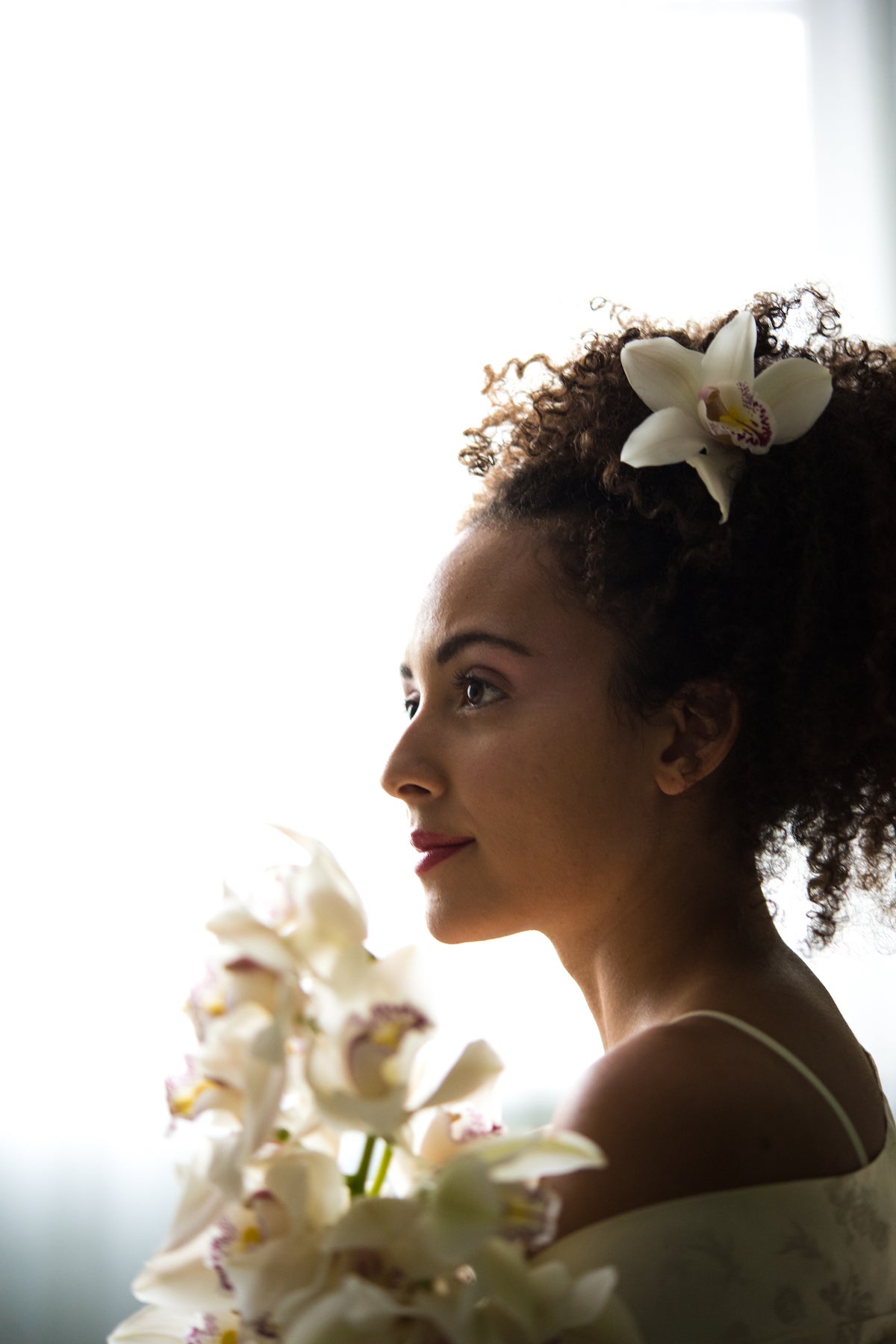 Woman holding flowers in room flooded with natural light