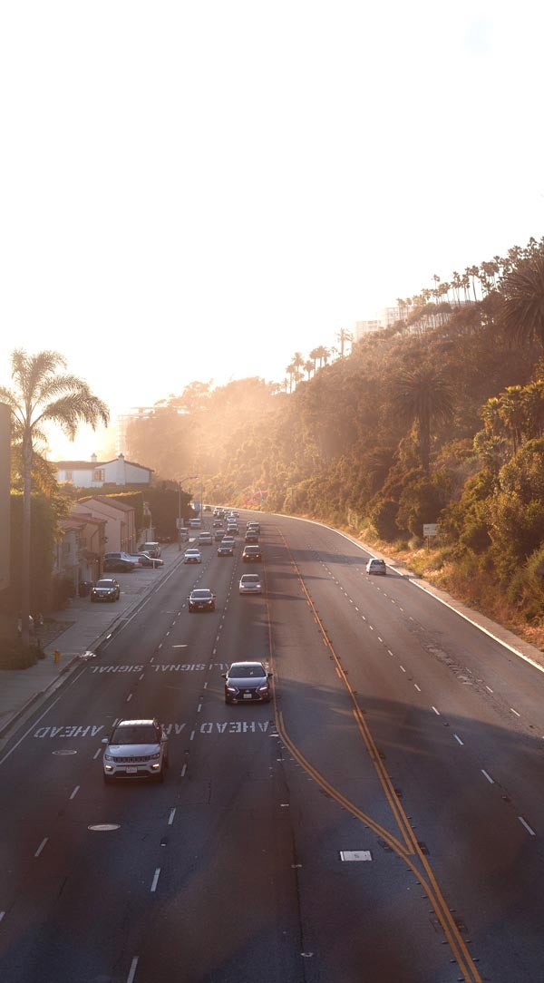 Edited photo of highway lined with palm trees with exposure adjusted