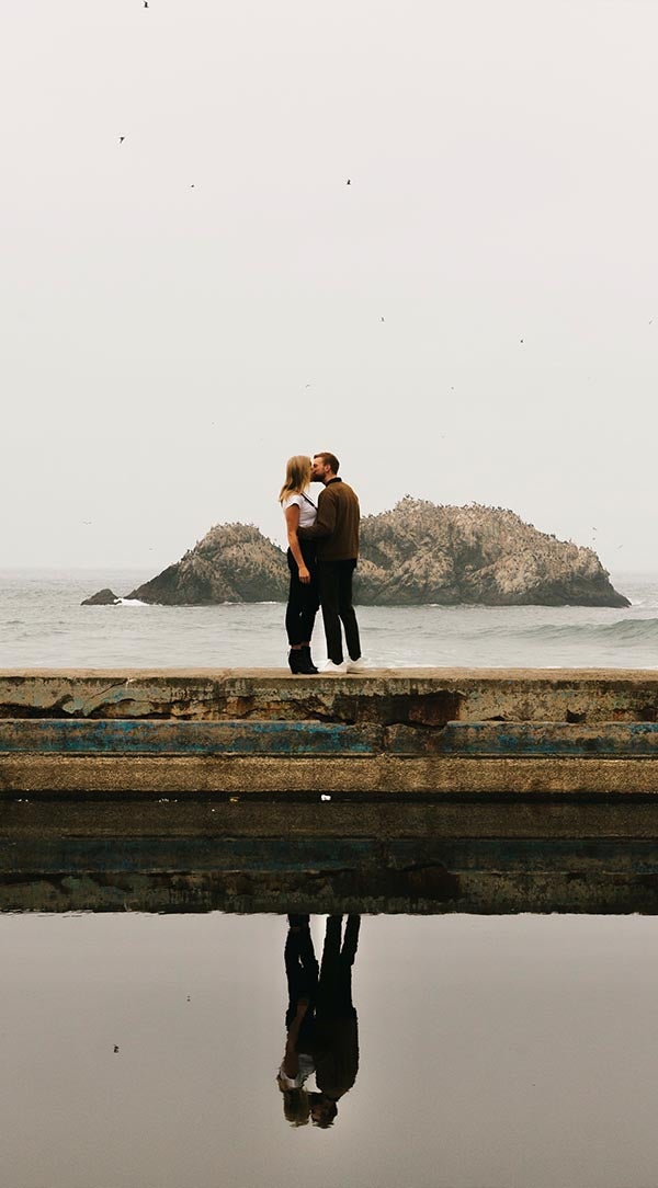 Edited photo of couple kissing on dock with shadows adjusted