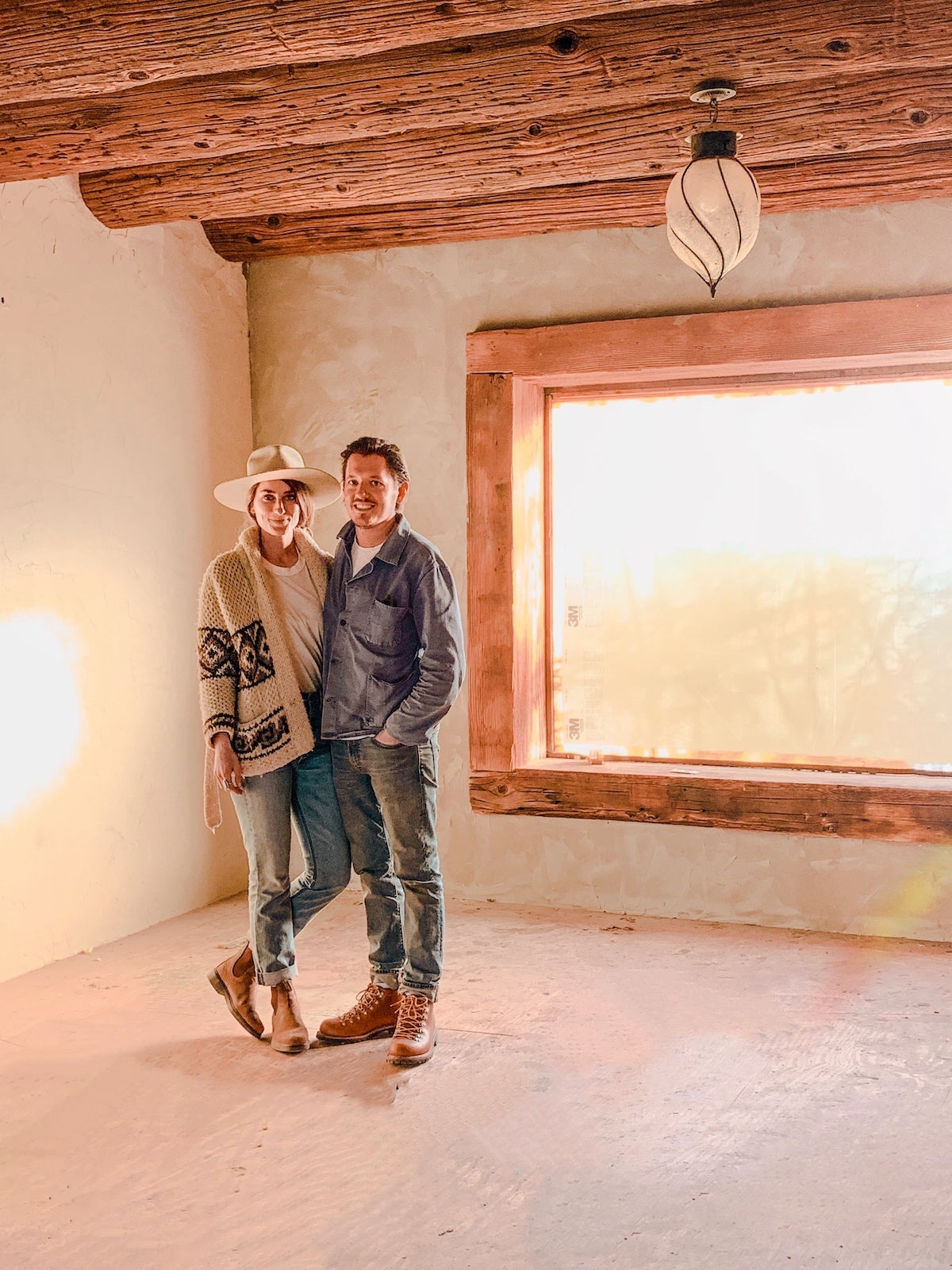 Sara and Rich stand in an empty room being renovated at the Joshua Tree House
