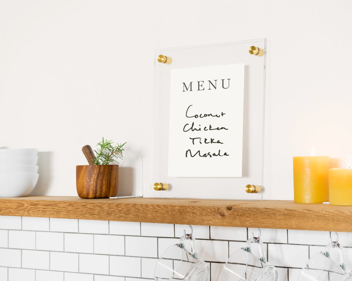 Floating frame with menu written on it resting on mantel