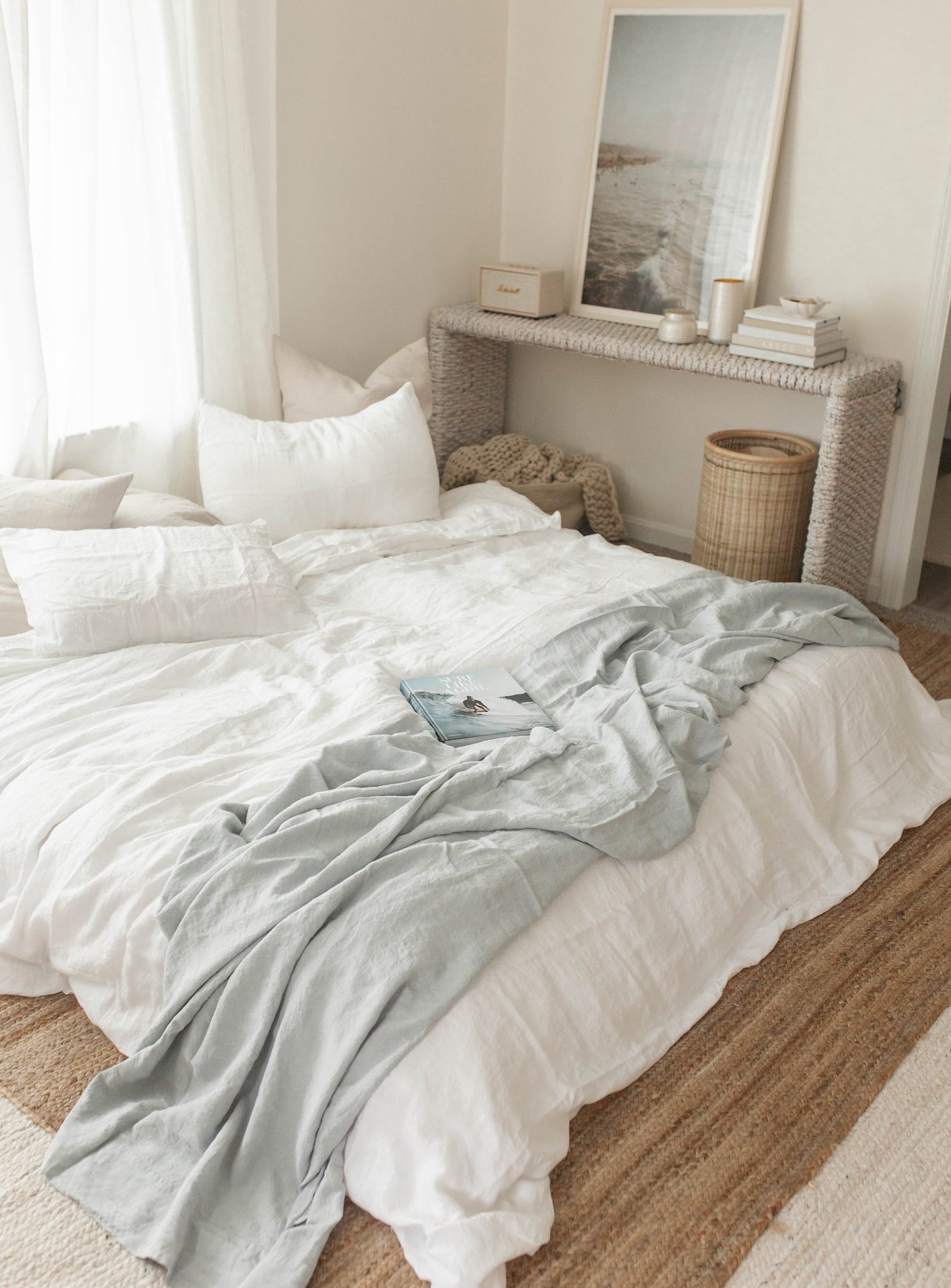 Bedroom with white bedspread, wicker furniture, and light neutral palette