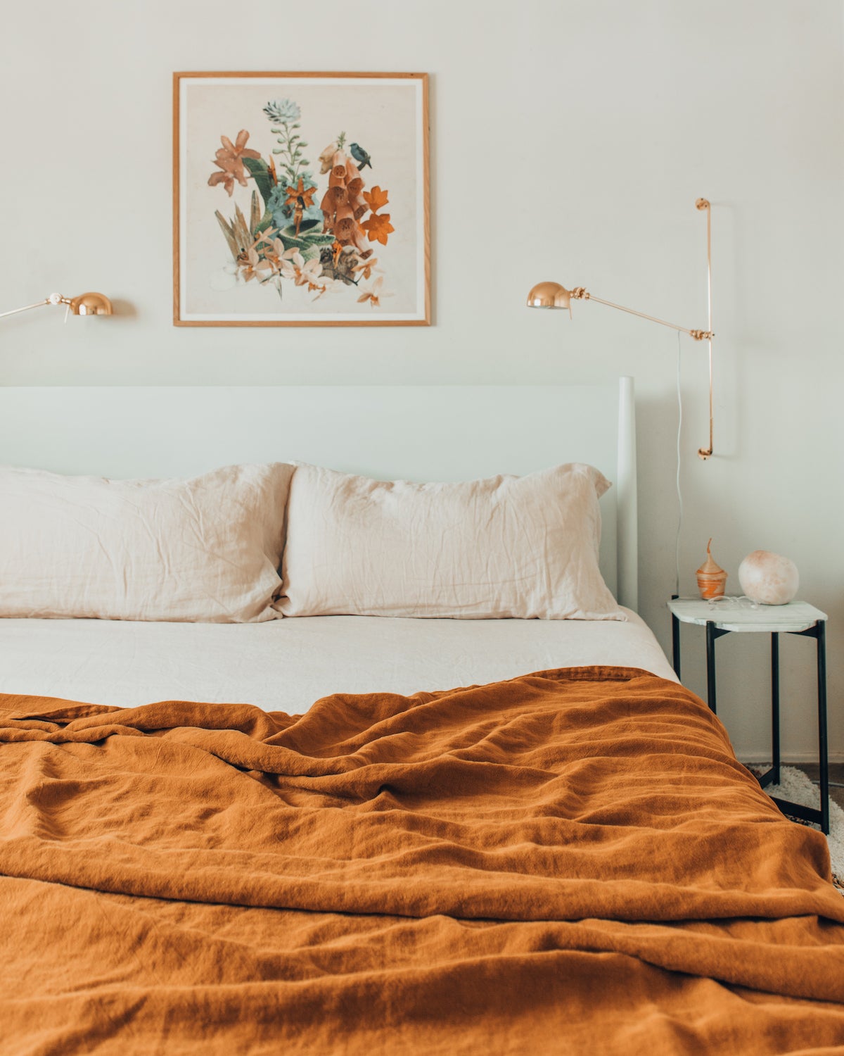 Burnt orange bedspread in an otherwise white room