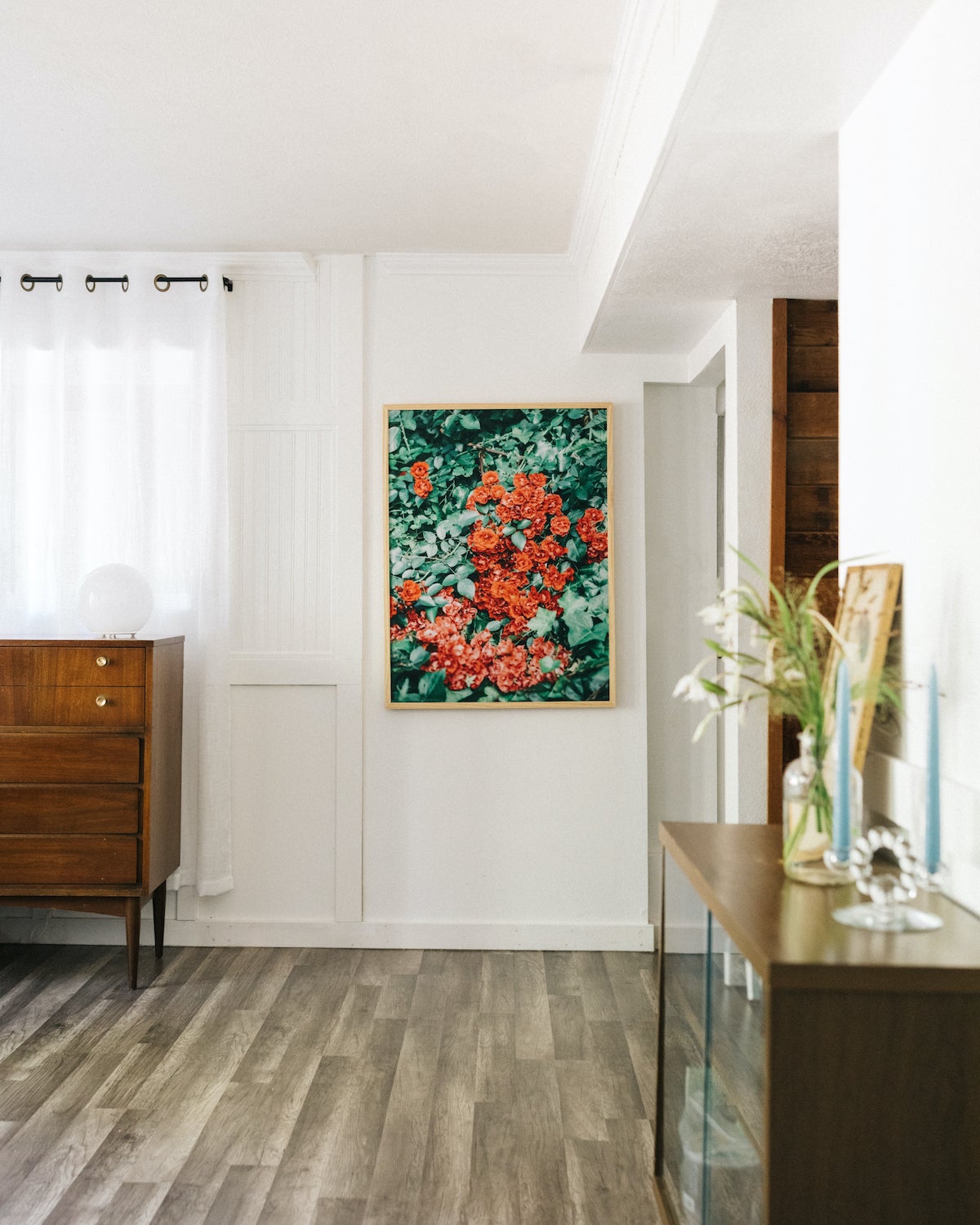 Photo by Kelly Kang of large framed photo featuring red flowers in minimalist roomscape