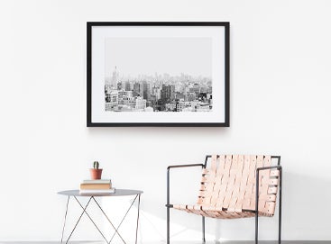 Single black and white frame on a wall with simple, minimalist furniture.