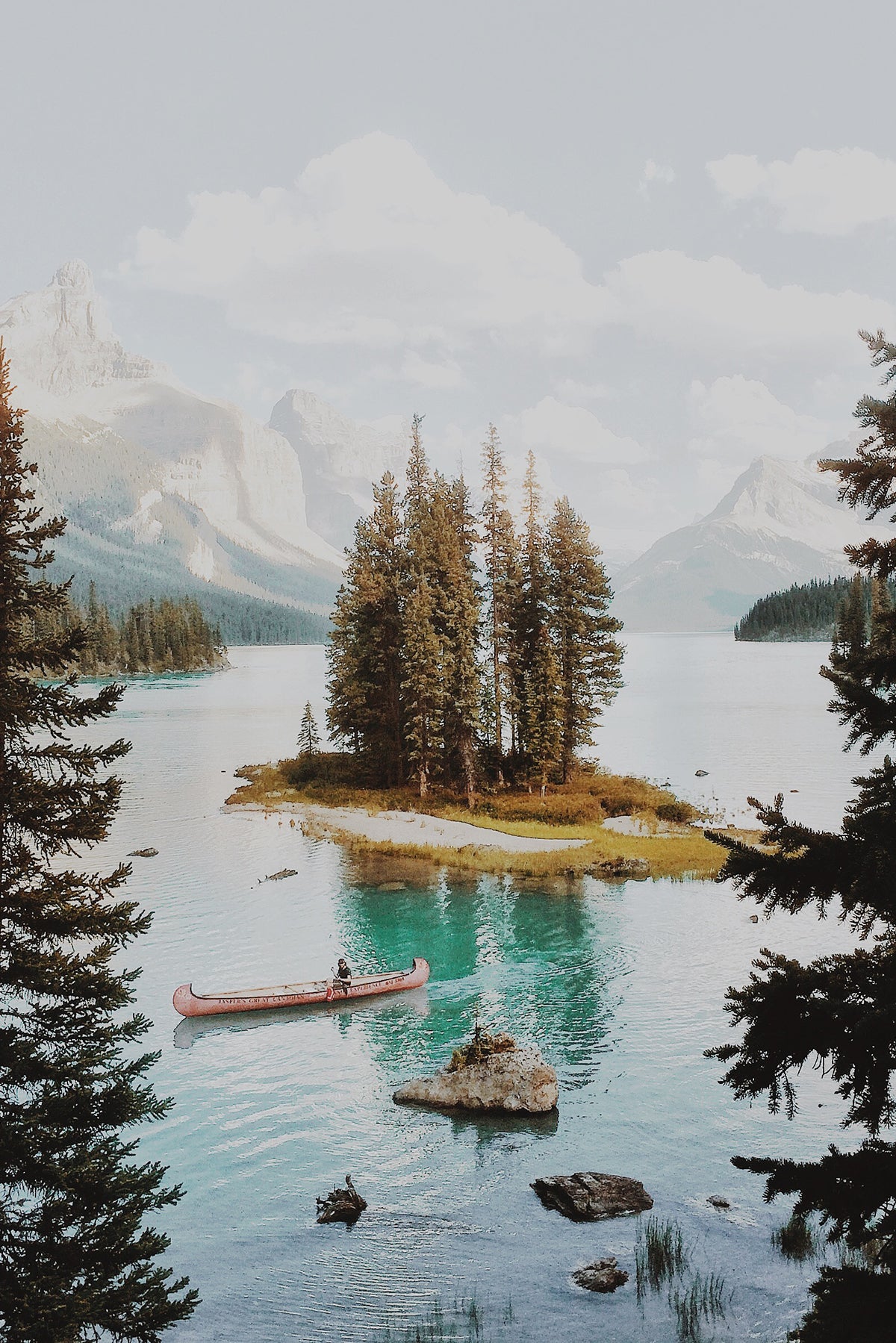Photo by Alex Strohl of small island in a lake surrounded by mountains