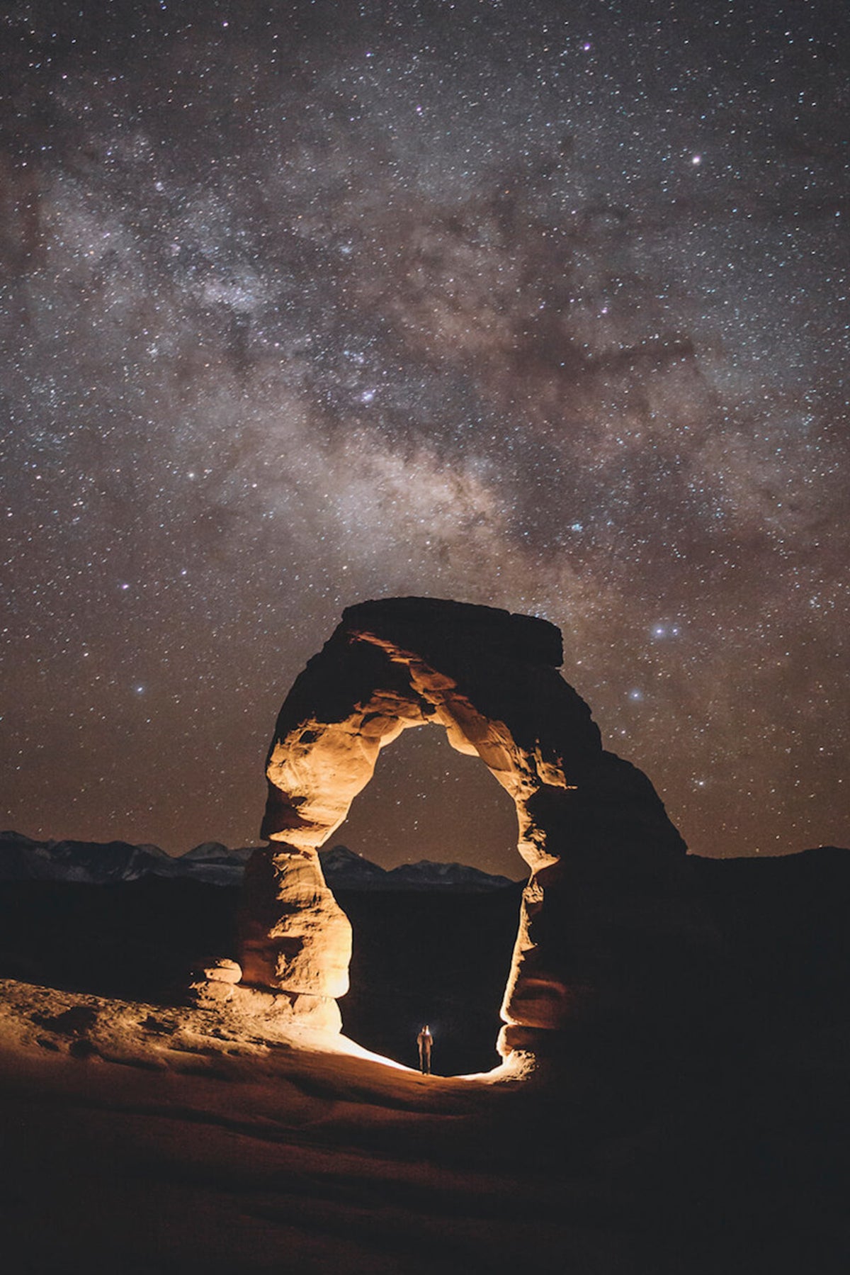 Photo by Garrett King of solitary arch under starry night sky