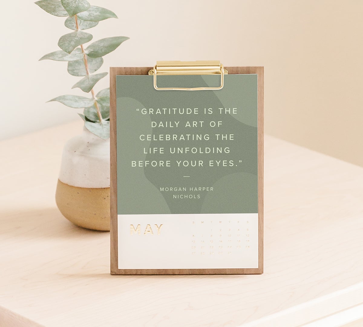 Artifact Uprising Walnut Desktop Calendar with inspiration quote over olive green background for month of May