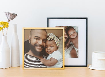 Artifact Uprising Framed Prints on dresser featuring photos of dad and baby