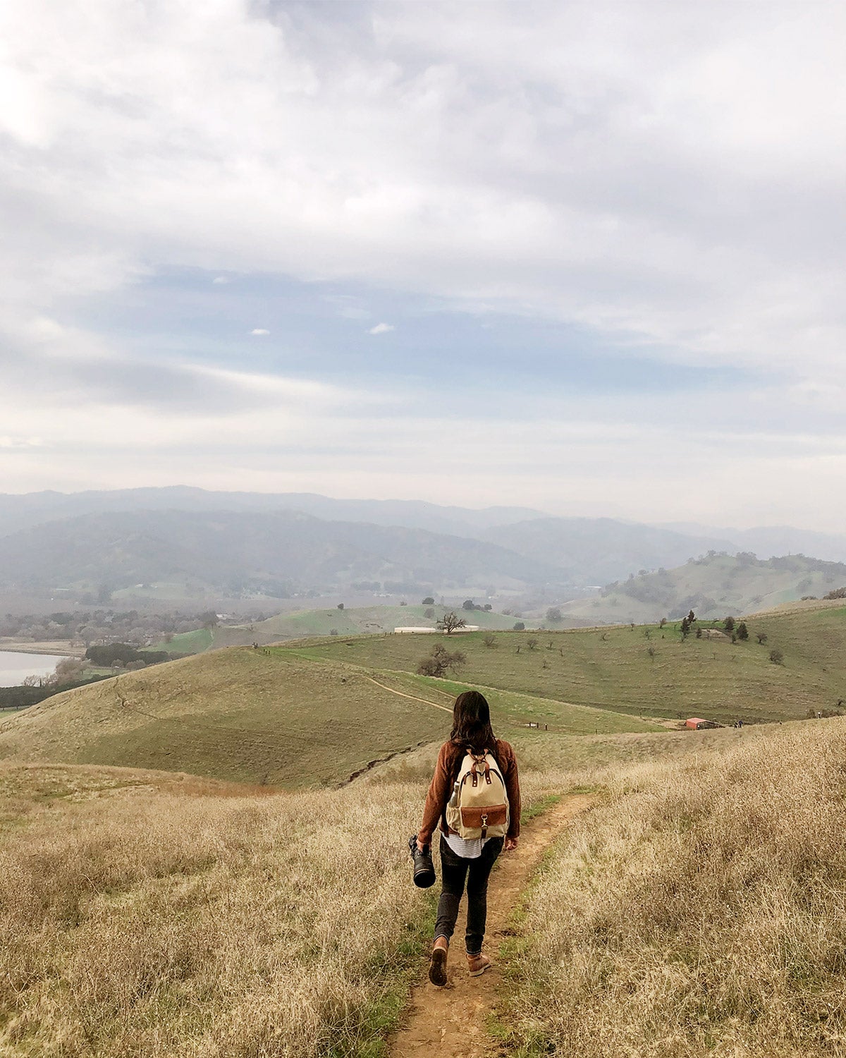 Woman on hiking trail peering out into landscape