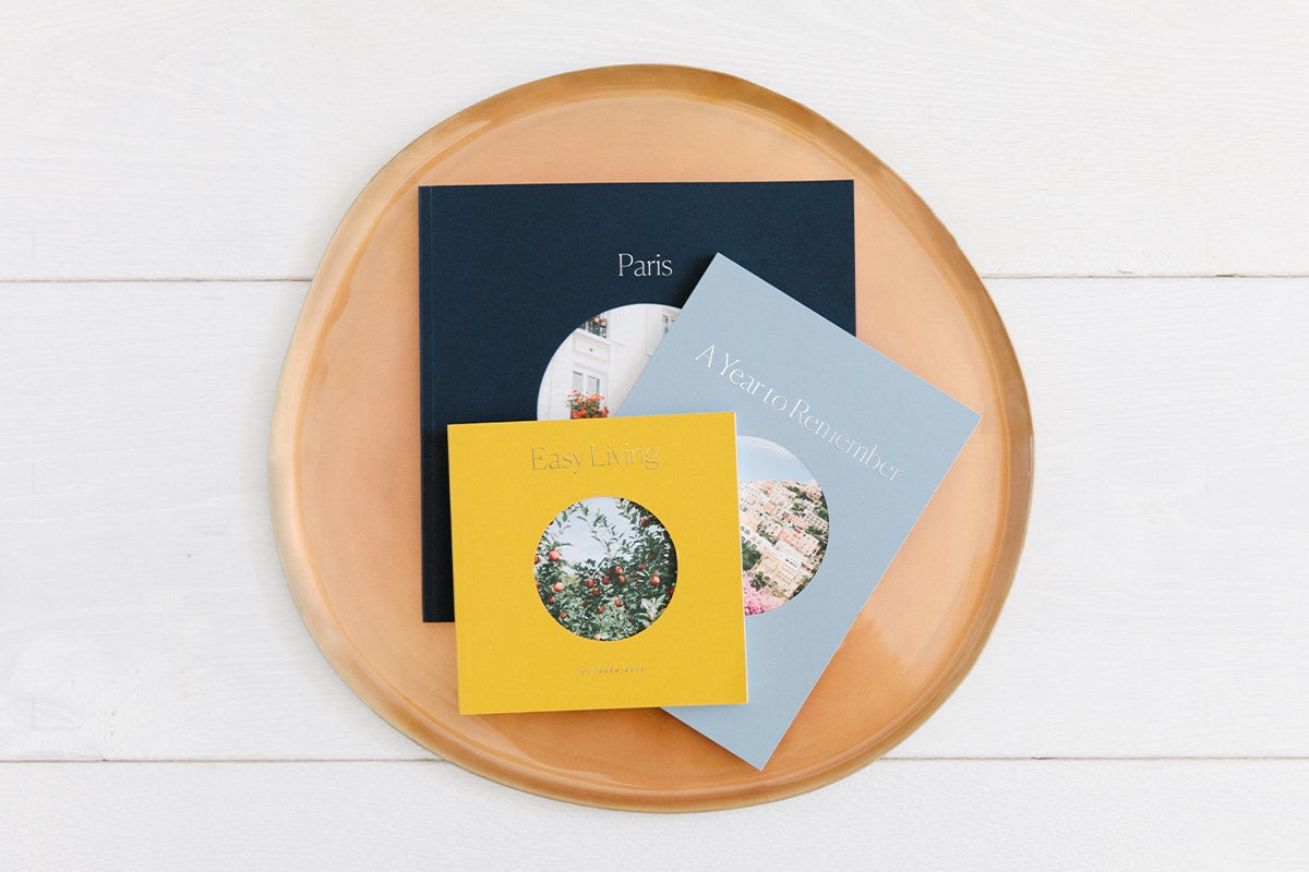 Three photo books arranged in wooden bowl