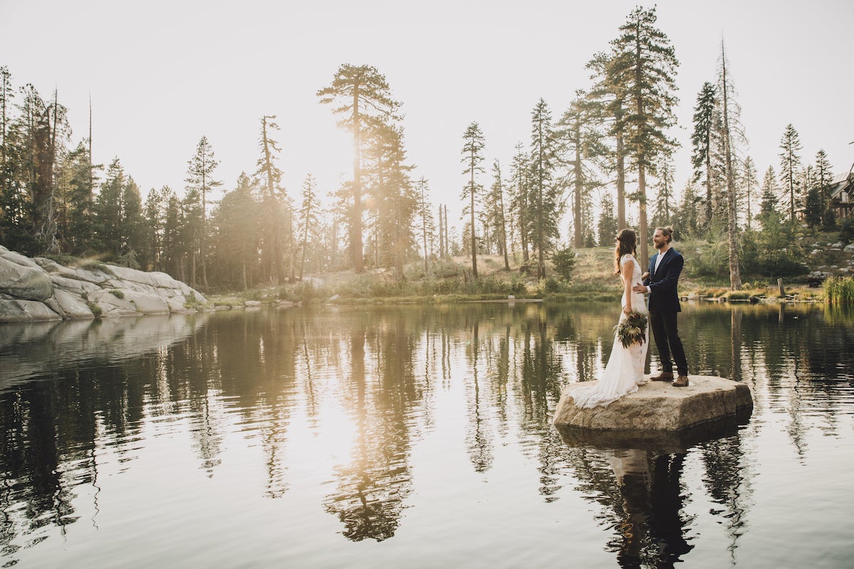 Couple standing on small island in pond at golden hour