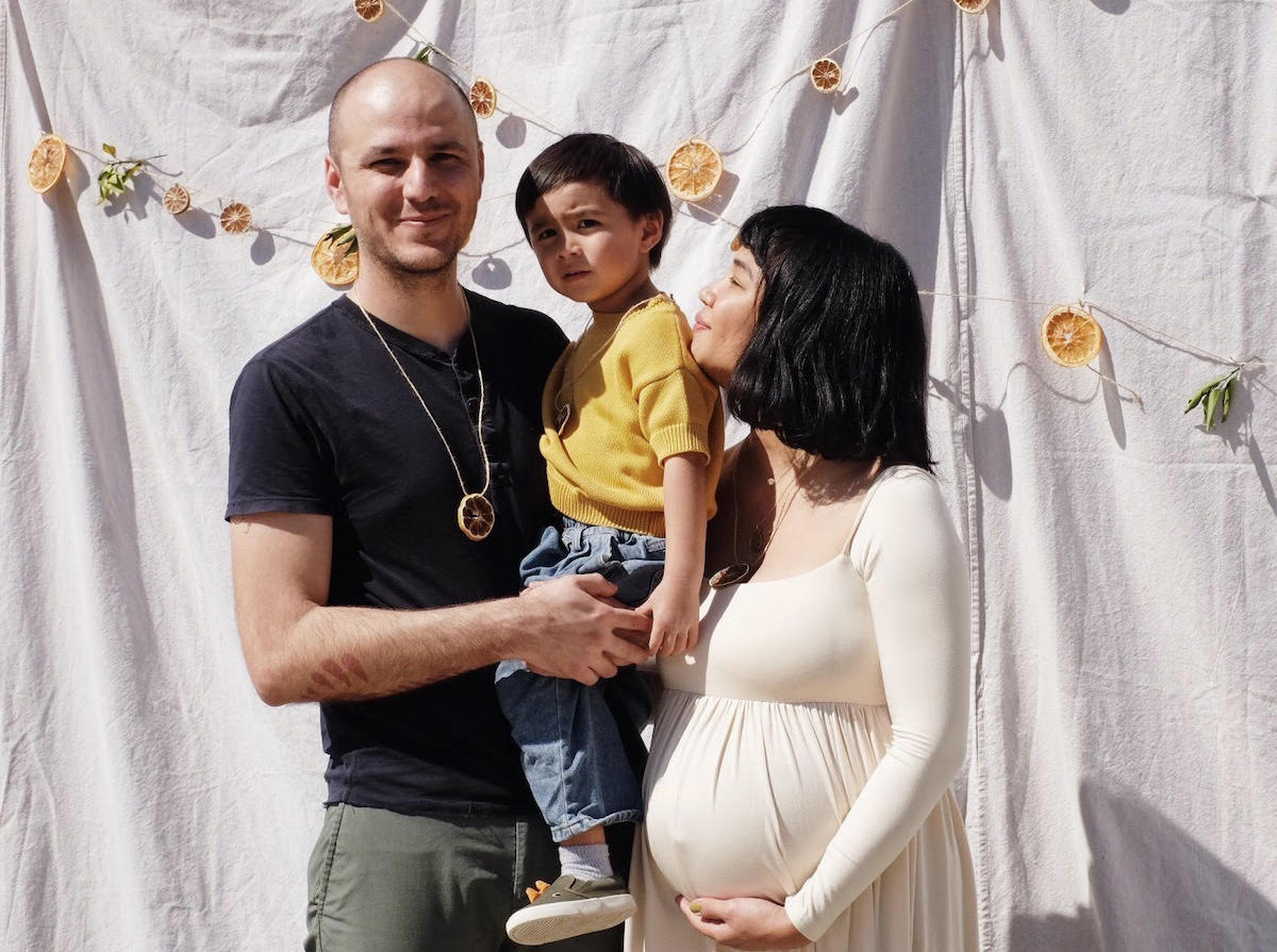 Family photo in front of DIY backdrop of white sheets and citrus slices