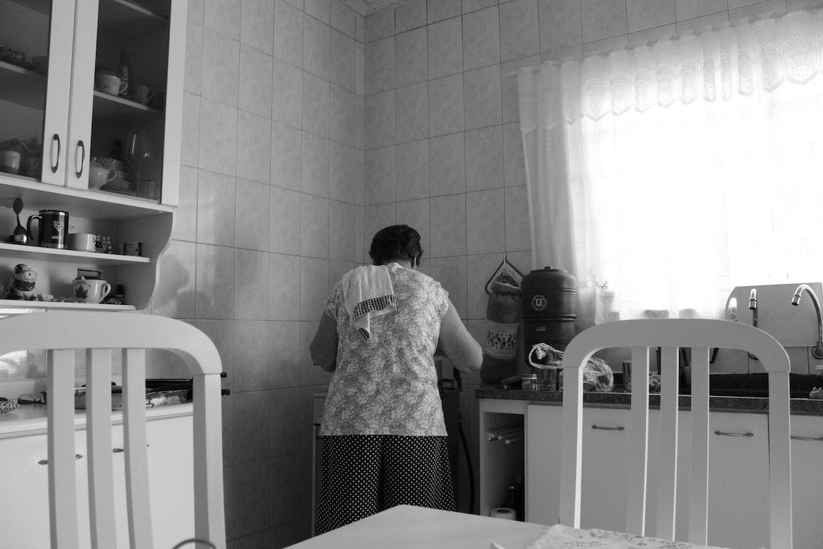 Woman cooking in kitchen with back turned to the camera