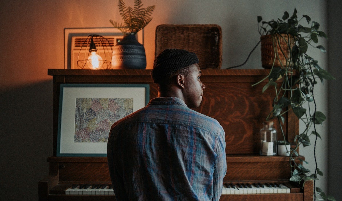 Man sitting in front of piano for at-home photoshoot