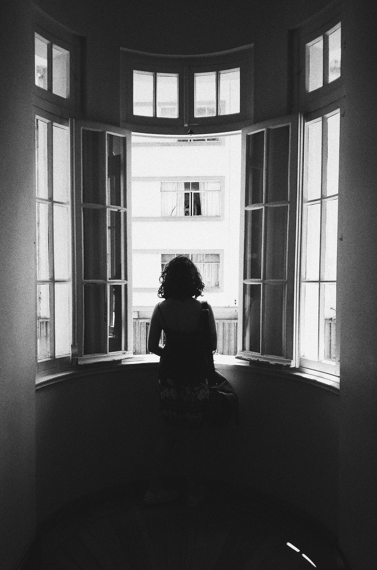 Silhouette of woman staring out apartment window