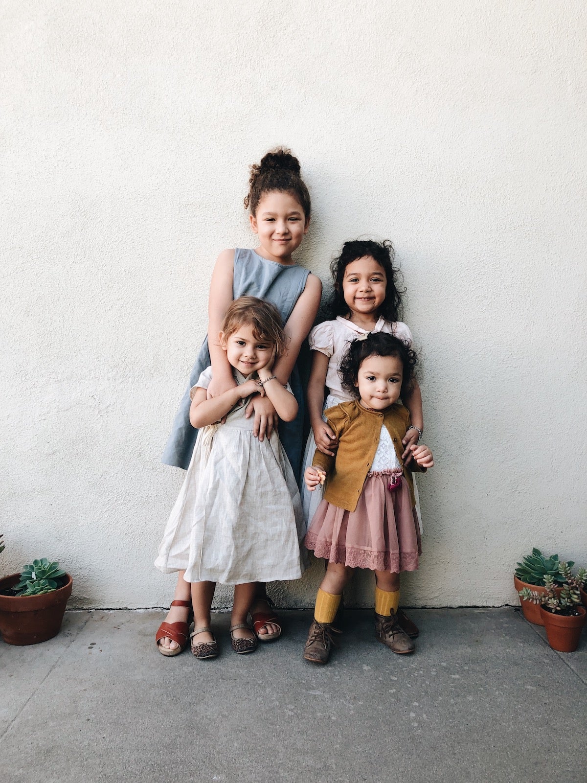 Four children lined in front of wall for family photo