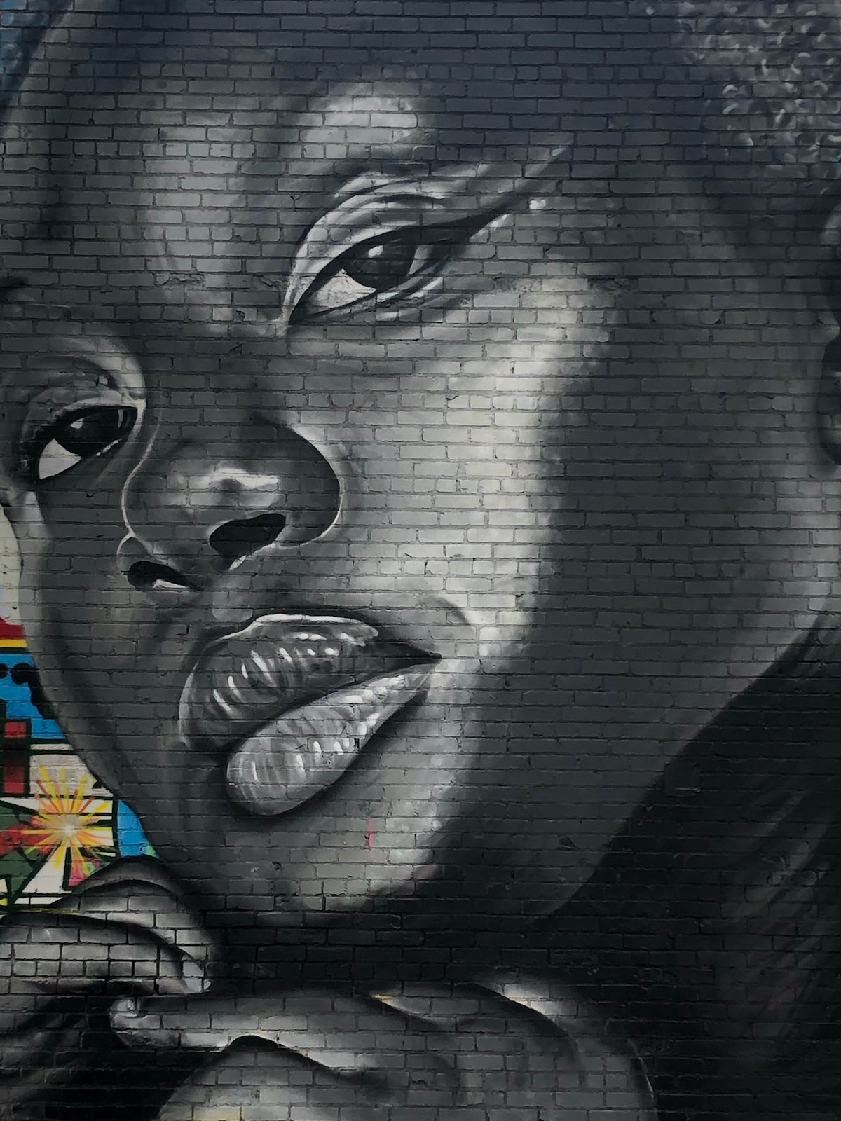 A mural of a black woman displayed on the side of a building