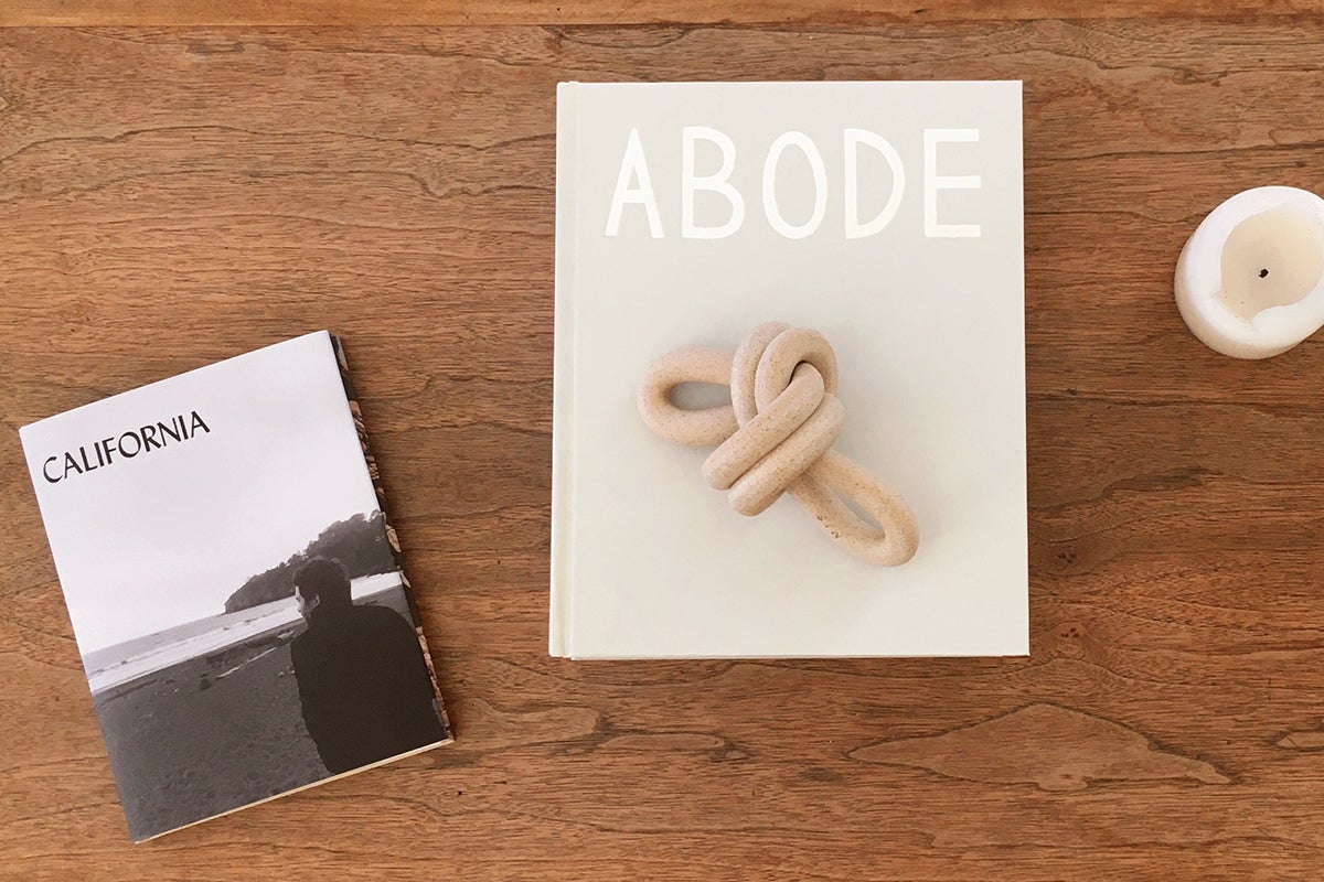 Custom coffee table book titled Abode resting on coffee table