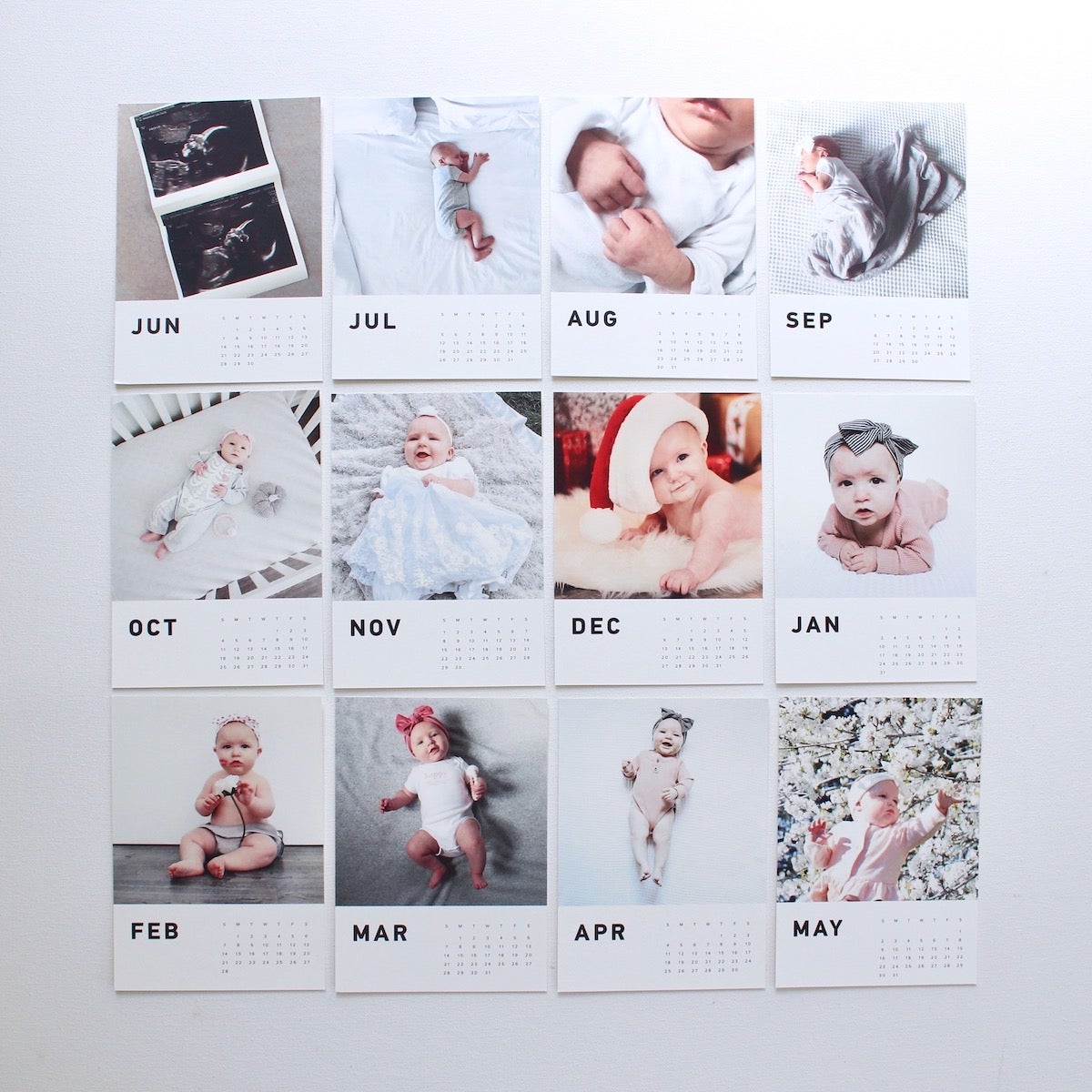 Calendar pages featuring baby photos laid out in grid