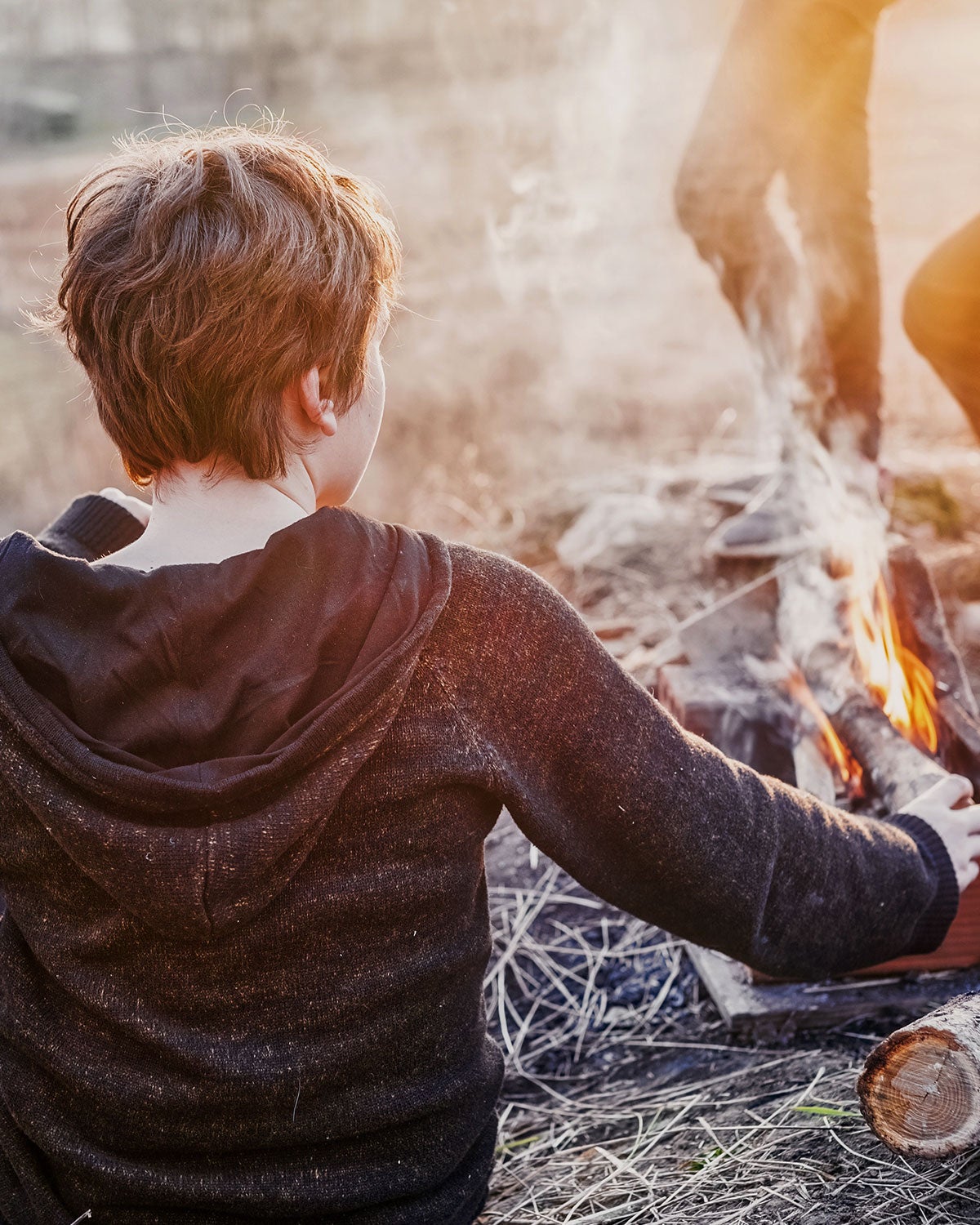 Boy tending a campfire
