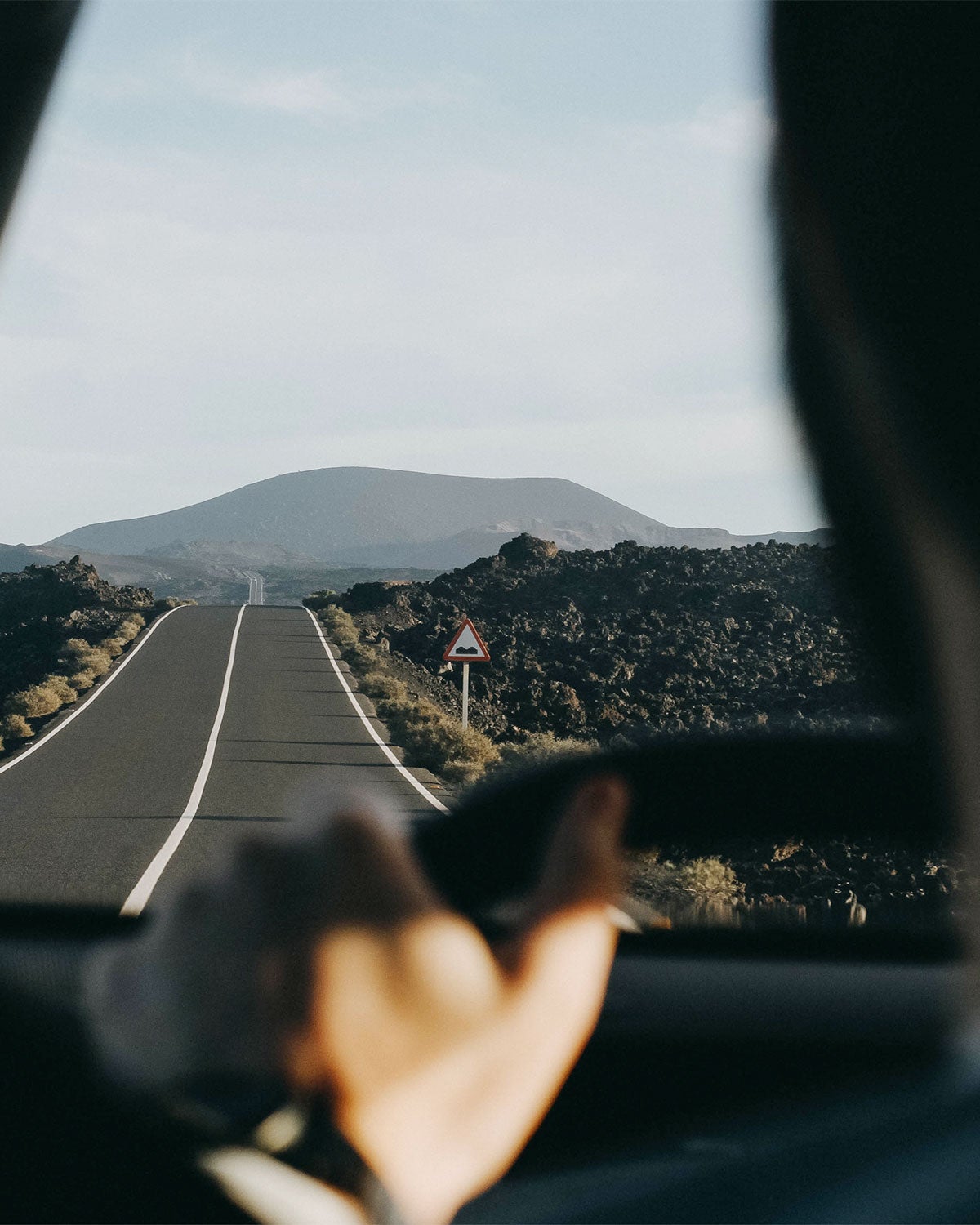 Driver's view of lush landscape along a remote road on a road trip