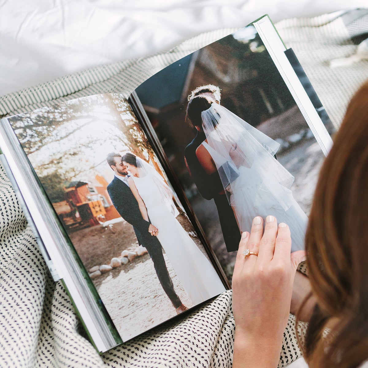 Woman flipping through interior pages of hardcover wedding photo book