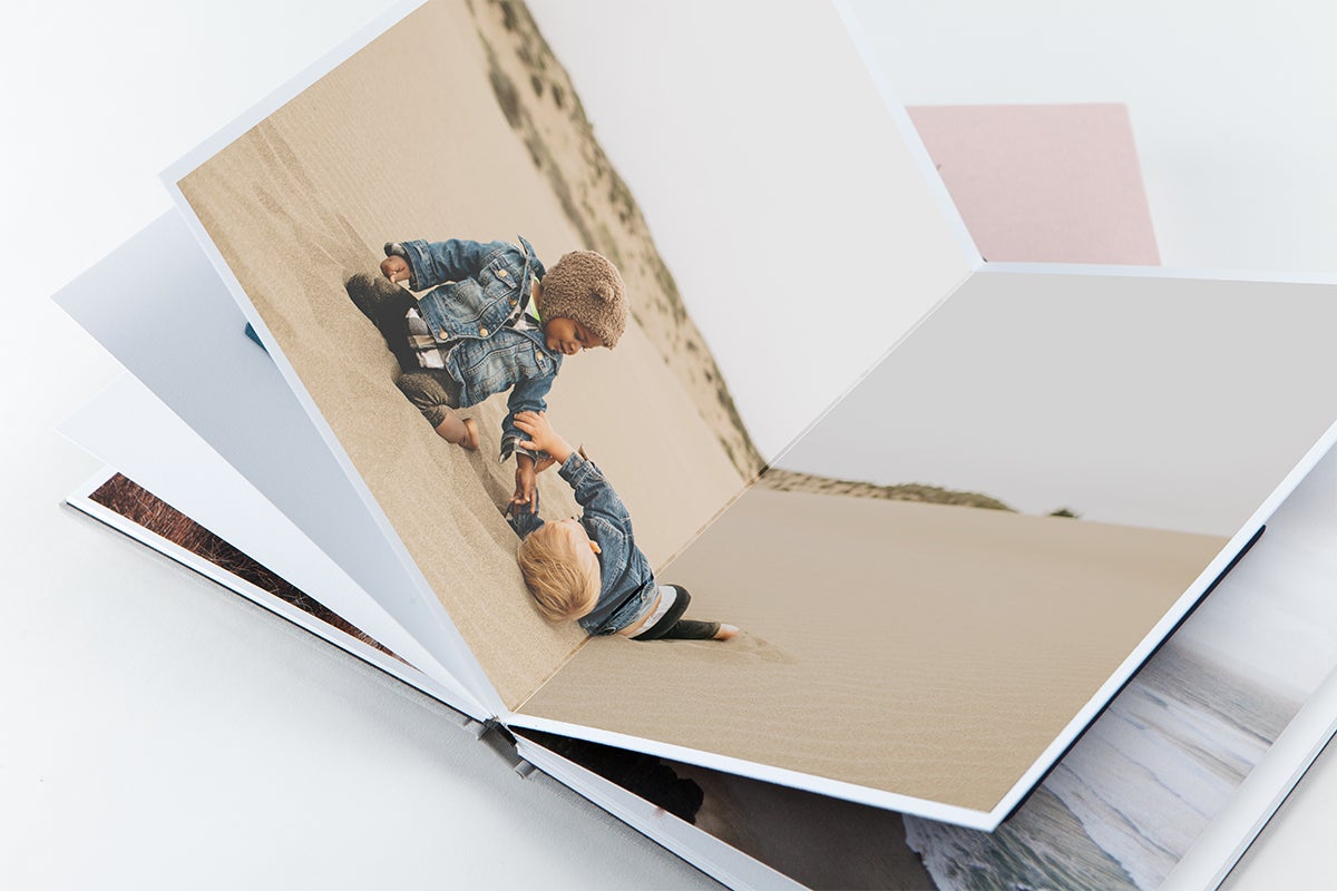 Layflat Photo Album opened to center panoramic spread of two little boys playing in sand