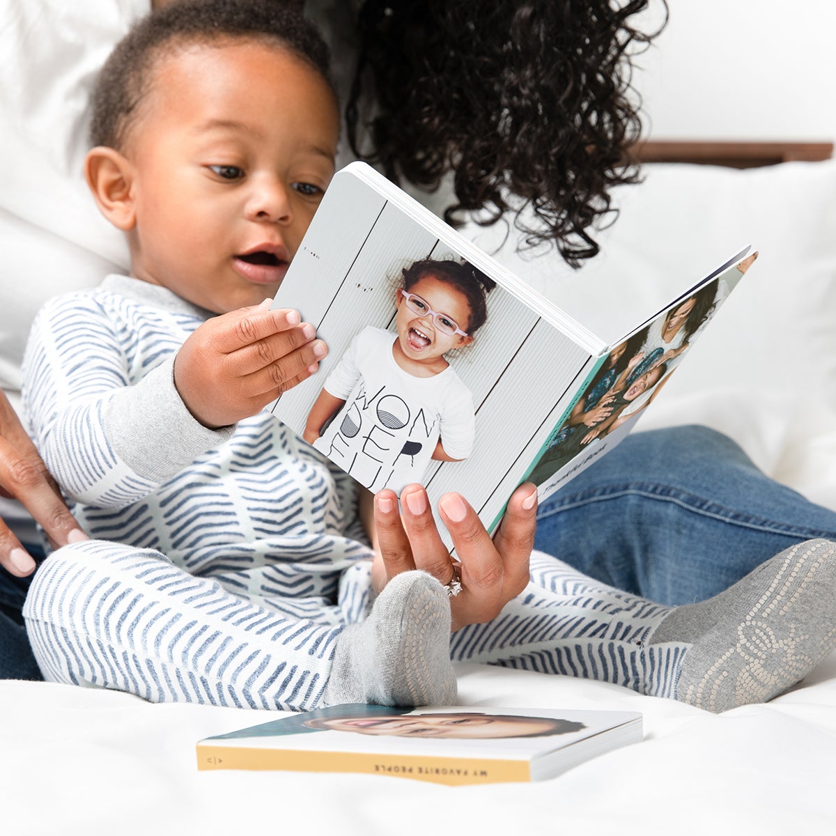 Baby in pajamas holding board book