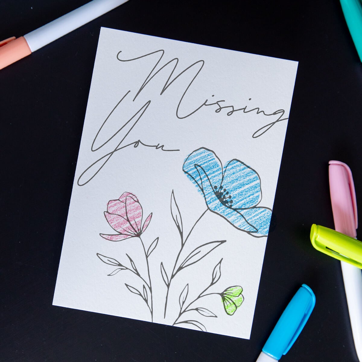 DIY postcard of black and white sketch of flowers that has been colored in by recipient