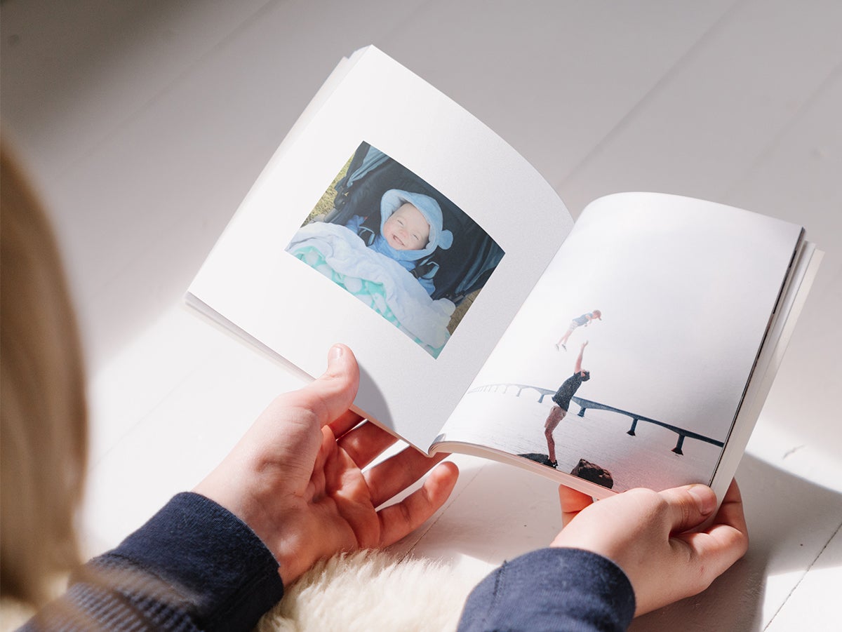 Softcover Photo Book opened to photo of baby on left page and father and toddler on right page