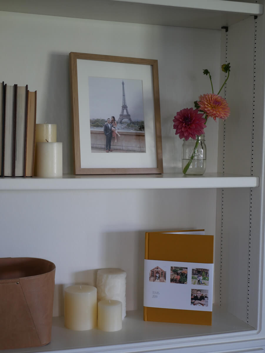 Recessed wall shelves with travel album, framed photo, candles, and other decor