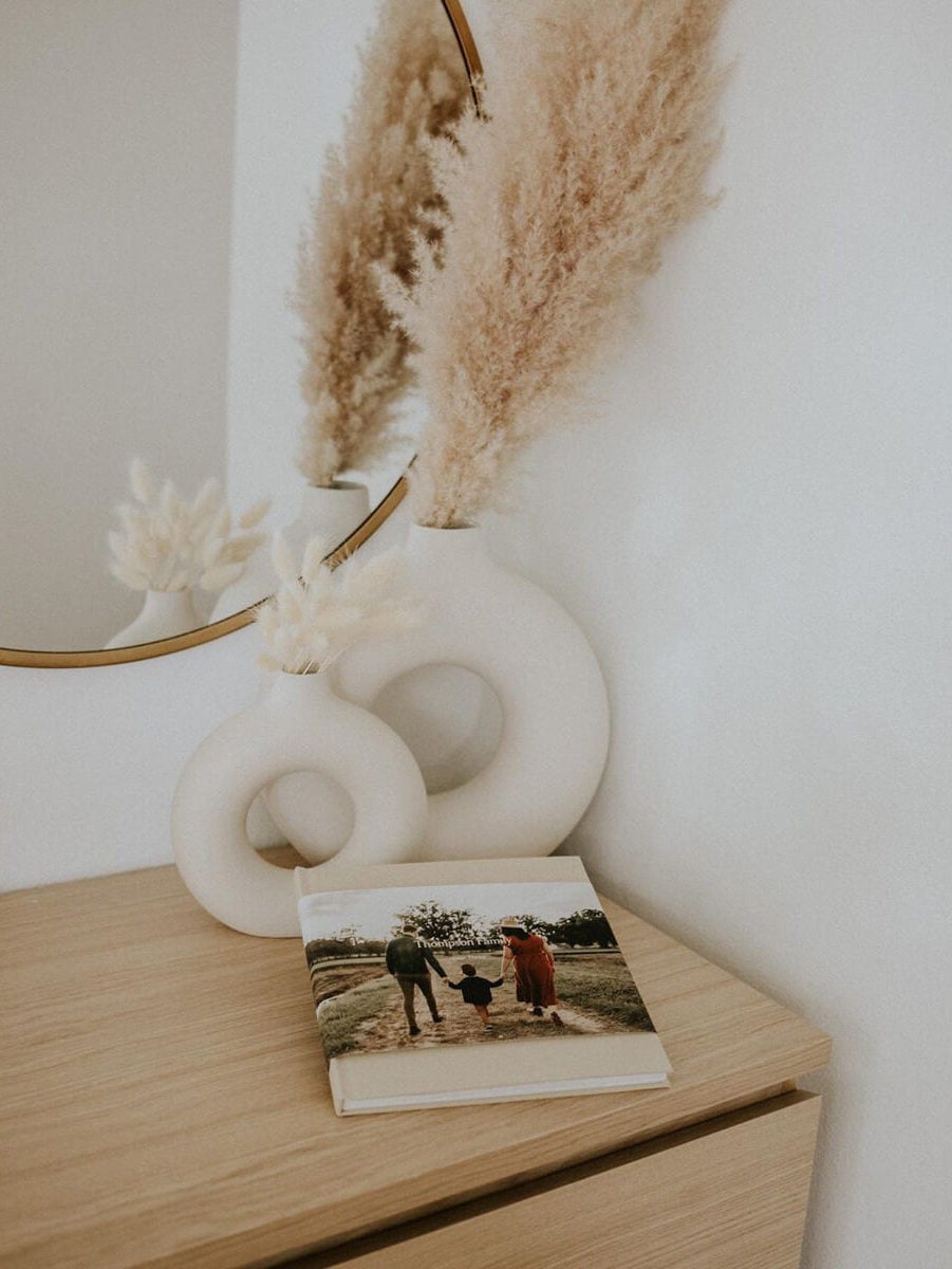 Pair of vases and family photo album sitting on dresser