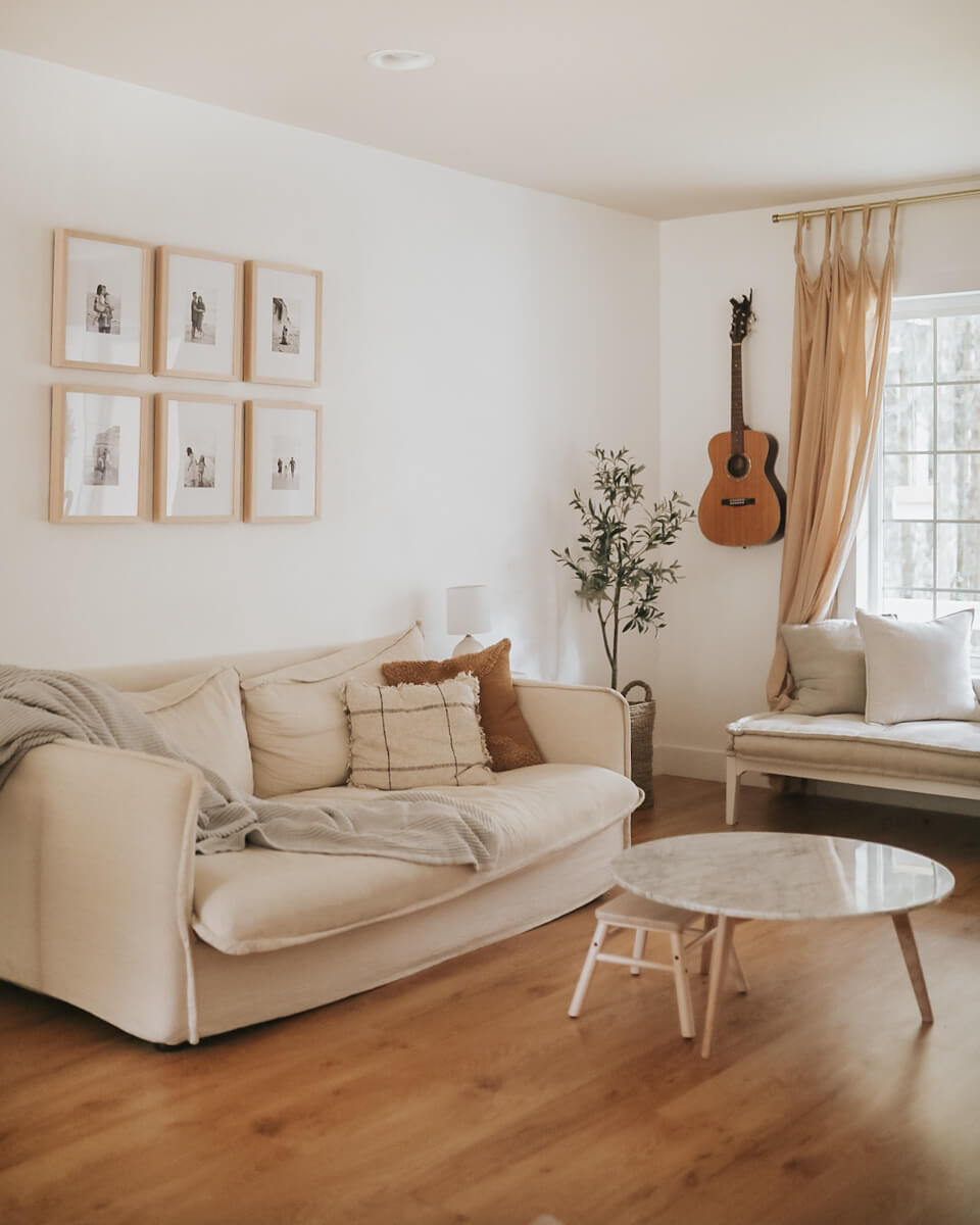 Gallery wall of family photos above couch in monotone living room