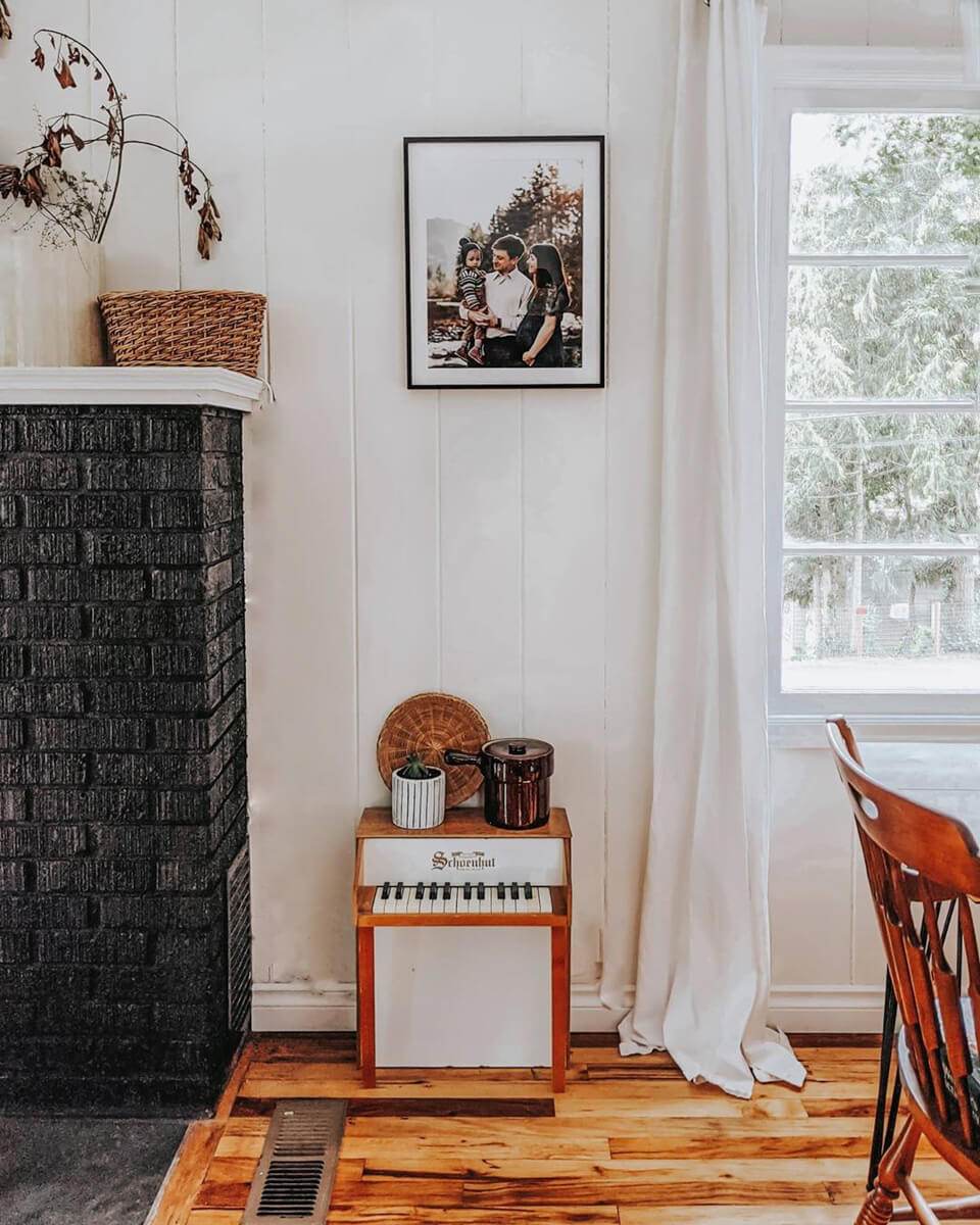 Framed family photo hanging above small children's piano