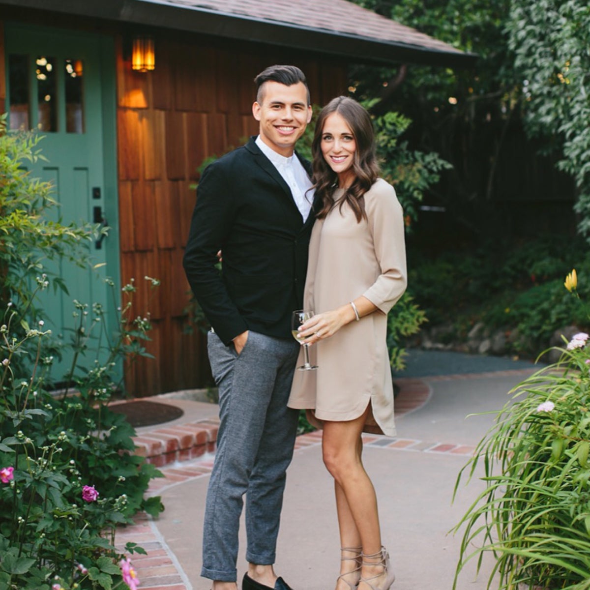 Couple posing for picture in front of home