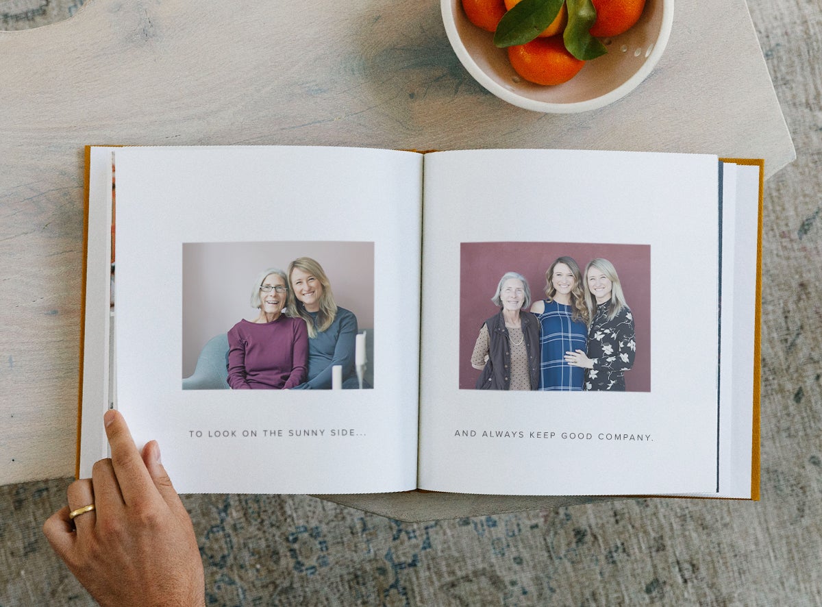 Woman's hand flipping through photo book with captions under images