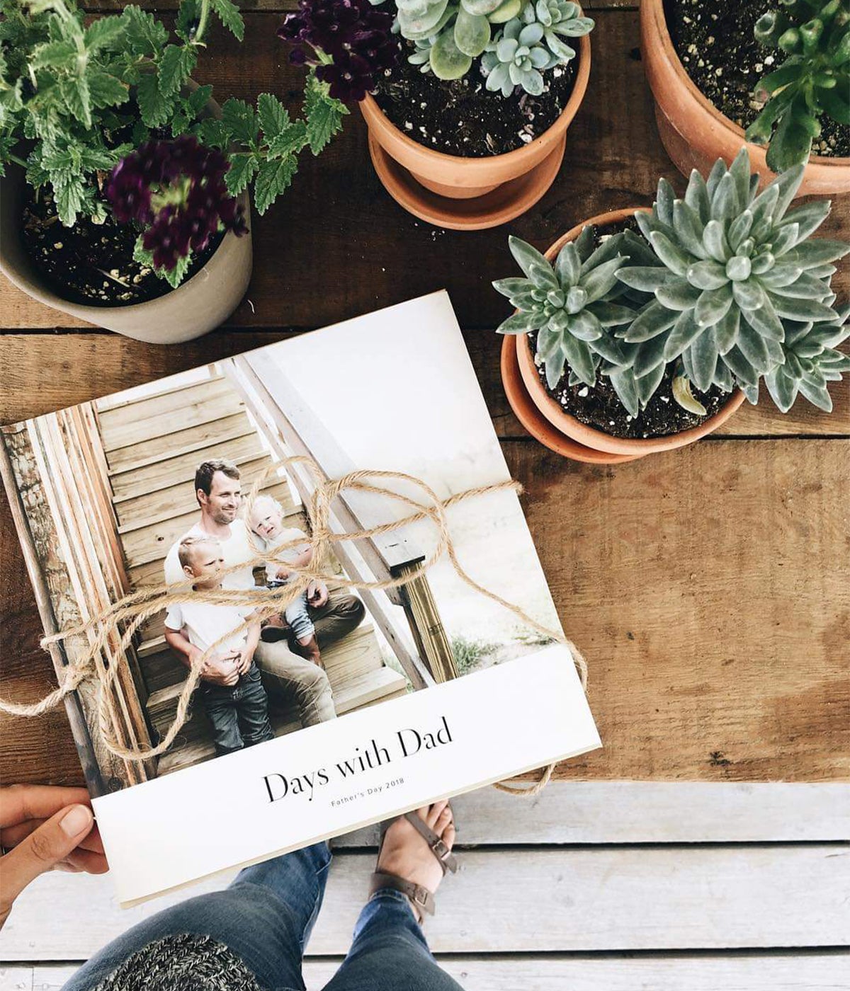Hardcover Photo Book titled days with dad on table next to succulents
